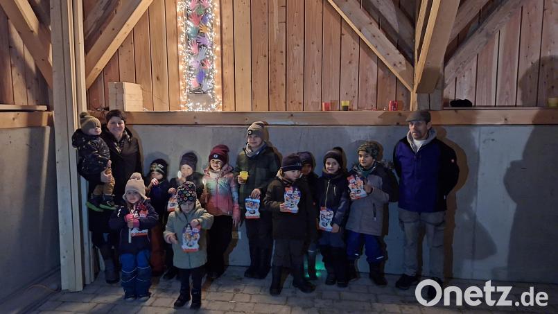 Das vierte und damit letzte Adventsfenster eröffnet die Bastelgruppe Thanstein (links Organisator Christina Mühlbauer). SRK-Vorsitzender Ulrich Knoch (rechts) übergab den Kindern ein kleines Weihnachtsgeschenk. Bild: mnt