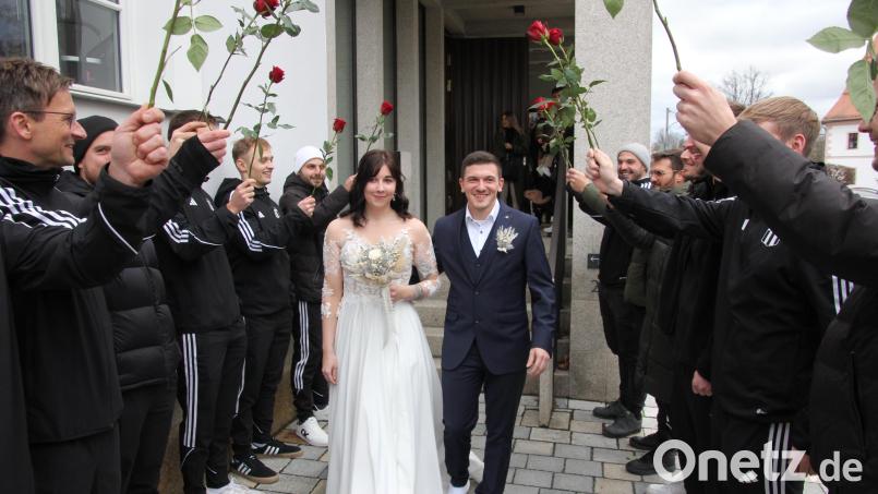 Freudestrahlend durchschreiten Vanessa und Lukas Baugärtner nach der Trauung im Rathaus Waldsassen das Ehrenspalier der TSV-Fußballer aus Konnersreuth. Bild: kro