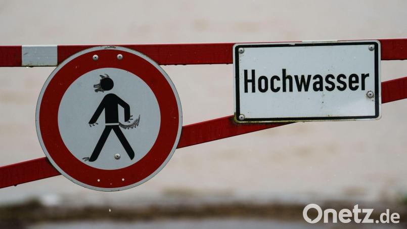 Ein Hochwasser-Schild steht an einem überfluteten Feld. Symbolbild: Andreas Arnold/dpa/Symbolbild