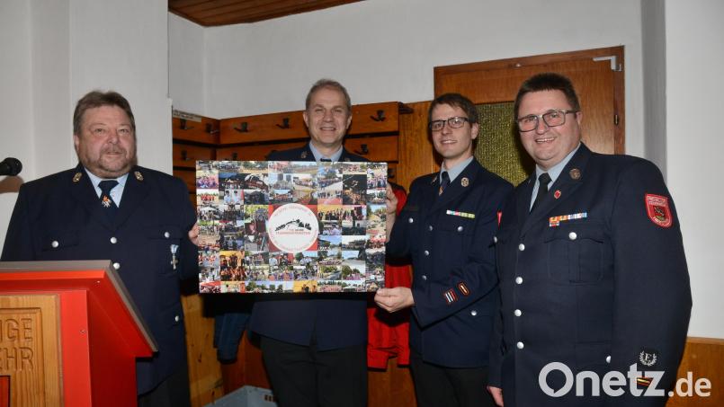 Vorsitzender Wolfgang Schraml und Kommandant Konrad Adam, Feuerwehr Hammerles, überreichen Kommandant Stefan Bäumler und Vorsitzendem Hans Wittmann eine Bildergalerie vom Jubiläum im Juni 2023. Bild: bey