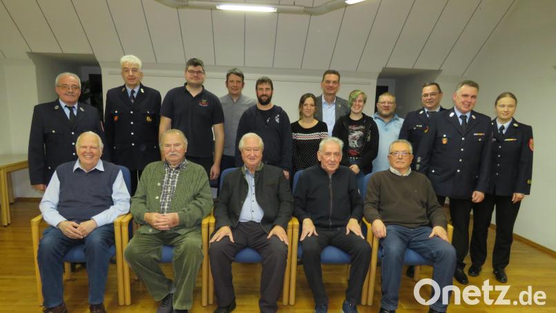 Mit Urkunden und Nadeln werden langjährige Mitglieder der Feuerwehr Altenstadt/WN von Wolfgang Müller (hinten, links) ausgezeichnet. Bild: adj