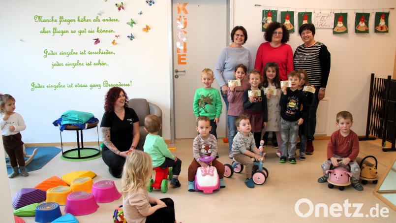 Petra Frind (links) und Regina Senft (rechts) vom Frauenkreis Wolfsbach überreichen Barbara Schaller (Mitte) und Lorena Vornloch (knieend) von der Ensdorfer Kindertagesstätte St. Jakob eine Spende von 1000 Euro. Bild: tra
