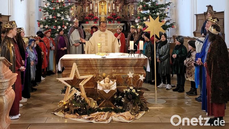 Die Sternsinger der Pfarrei Vilseck gestalten den Dreikönigsgottesdienst mit und versammeln sich zum Vaterunser um den Altar. Pater Jimmy Joseph dankt im Namen der ganzen Pfarrgemeinde. Bild: rha