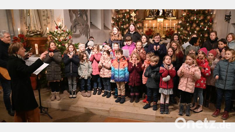 Der Altarraum in St. Barbara war fast zu klein für den Kinder- und Jugendchor St. Michaelpoppenricht, den Regina Probst leitete und Dominik Schrödl mit der Gitarre begleitete (beide links). Bild: gf