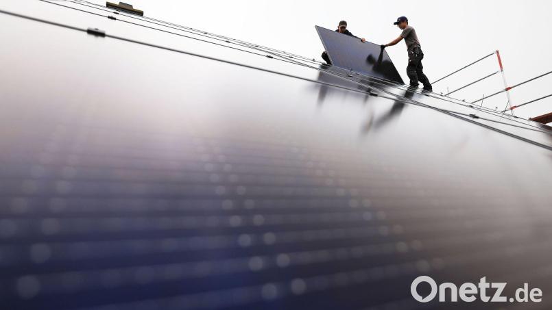 Handwerker montieren auf dem Dach eines Wohnhauses Solarmodule. Besonders in dieser Branche sind Arbeitskräfte gesucht. Bild: Oliver Berg/dpa