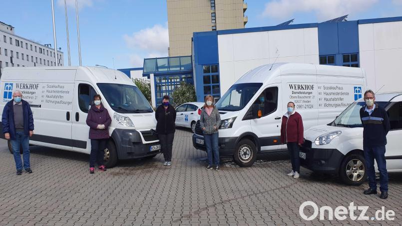 Teil des Teams im Werkhof Weiden vor den Fahrzeugen und dem Sozialkaufhaus. Bild: Michael Tschirn/exb