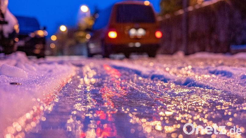 Eine dünne Eisschicht überzieht am frühen Morgen eine Straße. Bild: Armin Weigel/dpa/Symbolbild