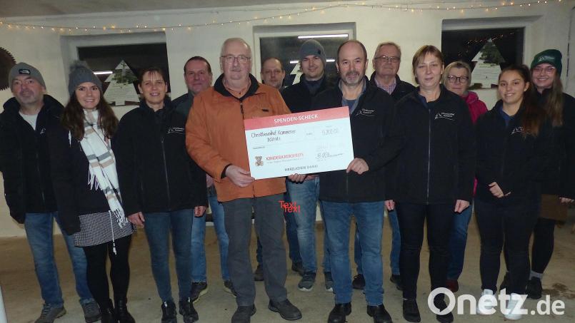 Bernhard Kammerer vom Christbaumhof (Sechster von rechts) überreicht im Beisein seiner Familie und Freunde symbolisch den Scheck von 5200 Euro an den Vorsitzenden der Kinderkrebshilfe, Herbert Putzer. Bild: sl