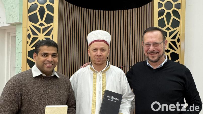 Der katholische Pater John (links) mit einem Koran, Imam Mehmet Salih Aydin (Mitte) hält eine Bibel, rechts der evangelische Pfarrer Klaus Wening. Alle drei halten übrigens islamische Gebetsketten in Händen. Bild: Matthias Bäumler/fph