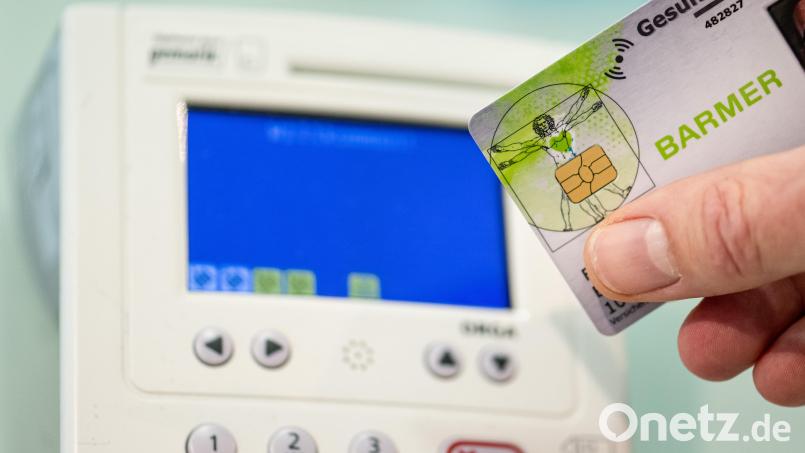 Ein Mitarbeiter einer Apotheke steckt eine Gesundheitskarte in ein Lesegerät. Symbolbild: Fabian Sommer/dpa