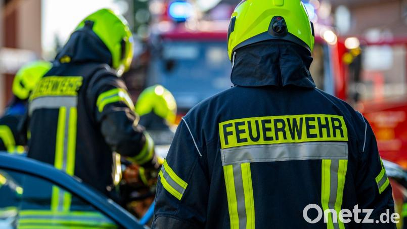 Feuerwehrleute stehen um ein Auto, das einen Unfall gehabt hat. Bild: David Inderlied/dpa/Symbolbild