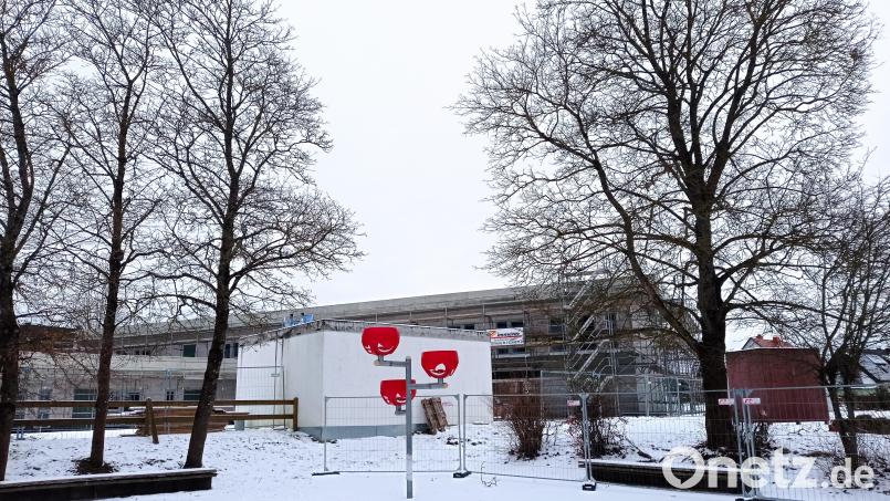 Auch die Bäume am Rand des ehemaligen Pausenhofes müssen weichen. Im Hintergrund der Rohbau des neuen Kinderhauses. Bild: fpoz