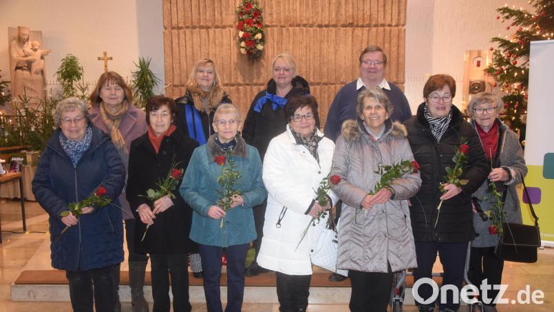 Pfarrer Hubert Bartel, Vorsitzende Irmi Schönberger und die Vorsitzende des Diözesanverbandes, Martha Bauer (hinten, von rechts), überreichen den Gründungsmitgliedern eine Rose und die geweihte Ehrennadel des Diözesanverbandes. Bild: fz