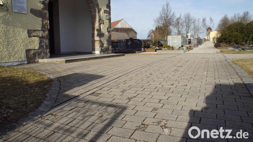 Wegen teilweise ausgewaschenen Betonsteinen beim Eingang zum Friedhof wird dort neues Pflaster verlegt. Bild: mmj