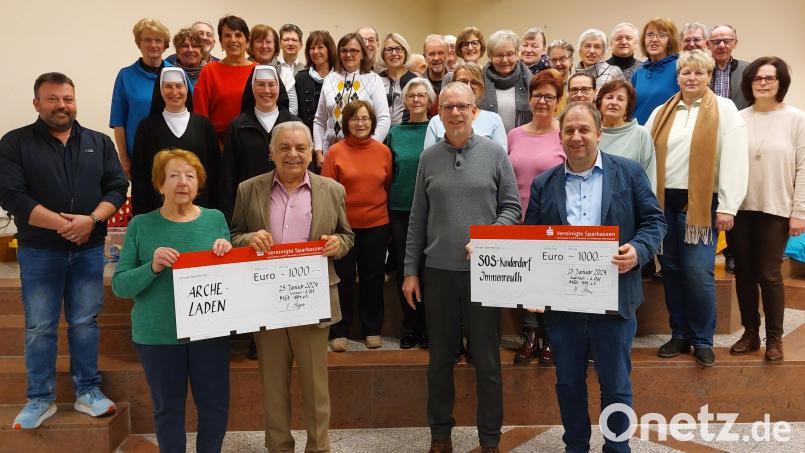 Freudestrahlend halten Doris Graf (vorne links) vom Auerbacher Archeladen und der Leiter des SOS-Kinderdorfs Immenreuth, Holger Hassel (vorne rechts), die symbolischen 1000-Euro-Schecks in den Händen. Bild: Reinhold Förster/exb
