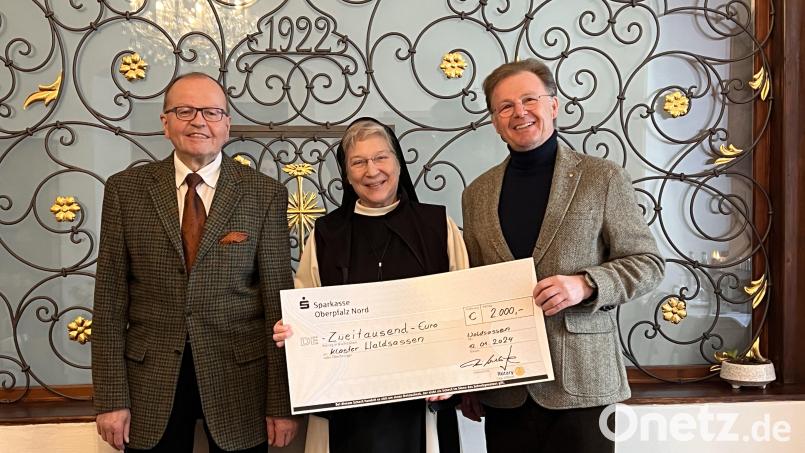 Gerhard Heindl (links) und Präsident Anton Schatzberger vom Rotary-Club Stiftland überreichten zur Sanierung der Klosterbibliothek einen 2000-Euro-Scheck an Äbtissin Laetitia Fech. Bild: Rotary-Club Stiftland/exb