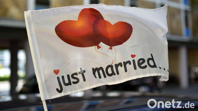 „Just married...“ (frisch verheiratet) steht auf einer wehenden Fahne, die an einem Autofenster festgemacht ist. Bild: Uwe Zucchi/dpa