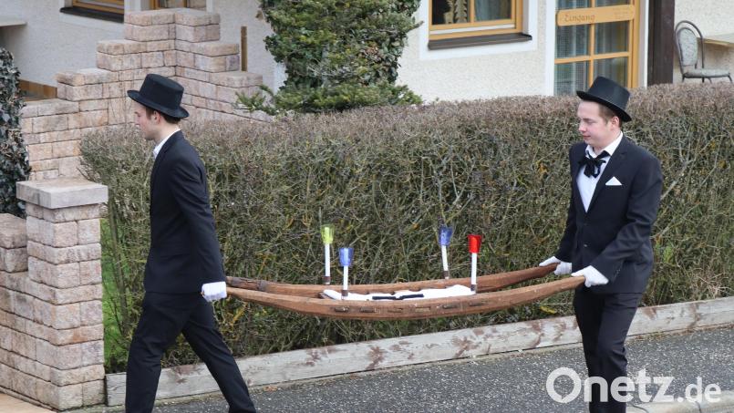 Luca Hollweck (links) und Andreas Jäger tragen beim Fischzug in Rieden die Misttrage mit dem Geldbeutel. Bild: mrr