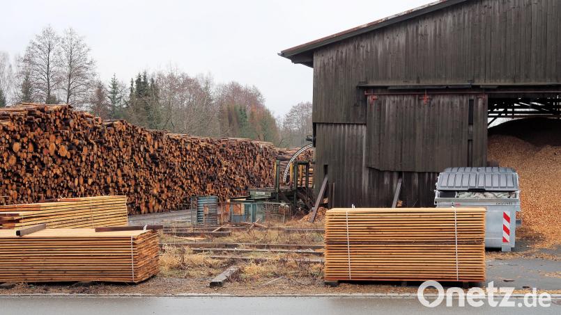 Nicht betroffen von der Schließung des Sägewerks ist die Produktion von Hackschnitzeln für den Friedenfelser Fernwärmebetrieb. Das angelieferte Rundholz aus dem Steinwald (links) wird künftig fremdgehackt und in der Halle (rechts) zwischengelagert. Bild: bsc