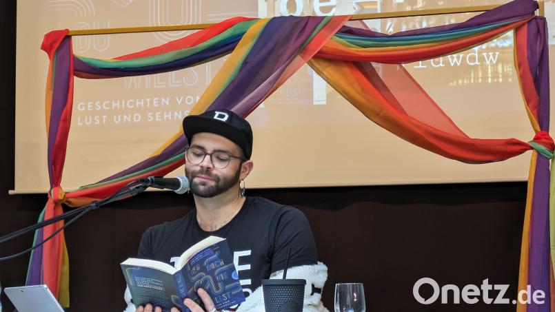 Beim Projekttag &quot;Diversität und Vielfalt&quot; in der Mittelschule Waldsassen liest Benni Cullen in der Aula aus dem Buch &quot;Lieb doch, wie du willst&quot; vor. Im Hintergrund ein Vorhang in den Farben des Regenbogens – Symbol für Vielfalt, Hoffnung und Frieden. Bild: pz