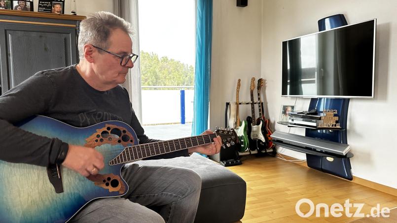 Egid Spies sitzt mit seiner Gitarre auf dem heimischen Sofa. Seit einer Covid-Infektion hat er starke kognitive Probleme. Plötzlich fielen ihm die über Jahrzehnte erlernten Gitarrengriffe nicht mehr ein. Bild: kle
