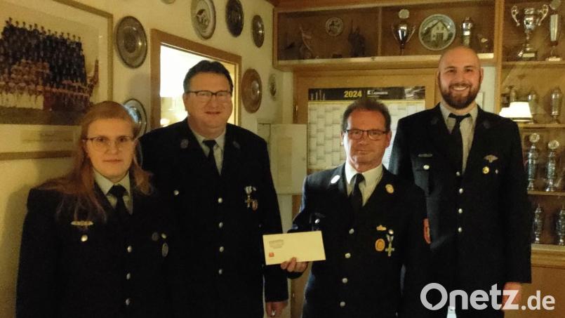 Juniorchefin Katrin Schönberger übergibt die Spende an den Vorsitzenden der Feuerwehr Rottendorf, Helmut Ries. Bild: Altmann/exb