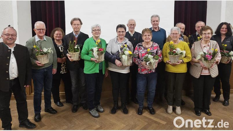 Vorsitzender Karl Ruhland (links) zeichnet treue Mitglieder des Obst- und Gartenbauvereins aus. Sie erhalten einen Blumengruß. Bild: Josef Fischer/exb