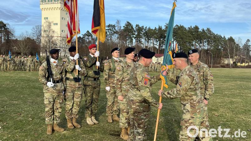 Vor den angetretenen Formationen auf dem Paradefeld überreicht Brigadegeneral Steven Carpenter (vorne Mitte) die Truppenfahne als formelles Zeichen des Verantwortungswechsels von Mark Morgan (rechts) an den neuen Command Sergeant Major Paul M. Fedorisin. Bild: mor