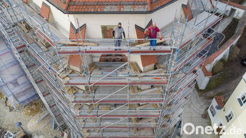 Eugen Schneidmüller (links) und Dominik Jung stehen auf einem Gerüst in 18 Metern Höhe an der Außenfassade des Altarraums der Pfarrkirche St. Marien und schauen in die Kamera einer Drohne. Arbeiten mit der Motorsäge in solcher Umgebung sind für sie Alltag. &quot;Das macht uns nicht nervös&quot;, sagt Eugen. Bild: Thilo Hierstetter/exb