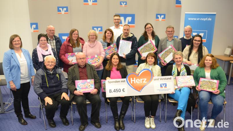 Die Empfänger der Spenden nehmen die Zuwendungen aus den Händen von Geschäftsstellenleiterin Daniela Kühner (links) und stellvertretendem Regionalmarktleiter Gerhard Schriml (hinten, Mitte) entgegen. Diesmal stehen Bildungseinrichtungen und Kirchen im Vordergrund. Bild: dob