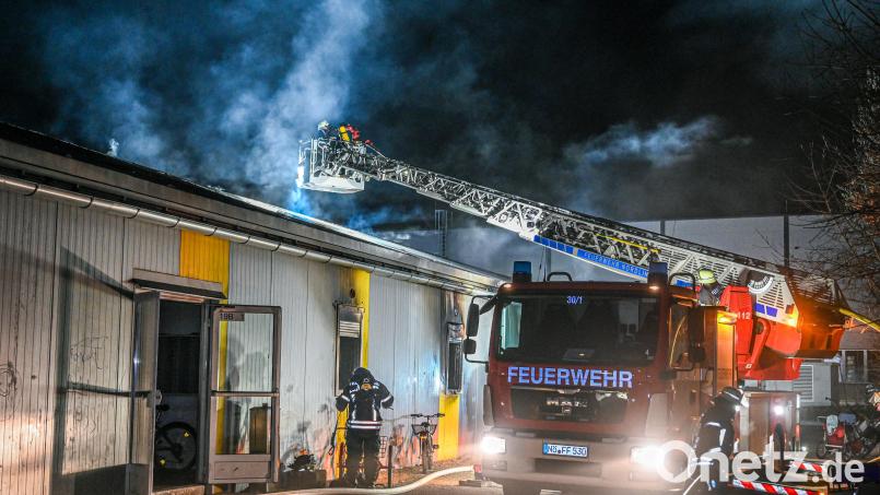 Mitarbeiter der Feuerwehr löschen einen Brand in einer Asylbewerberunterkunft. Bild: Marius Bulling/dpa