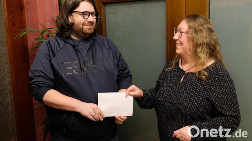 Nach geheimer Abstimmung der Versammlungsteilnehmer überreicht GSG-Vorsitzende Petra Danzer an Pfarrer Johannes Bosco die Vereinsspende von 1000 Euro für den Pfarrheim-Neubau. Bild: do