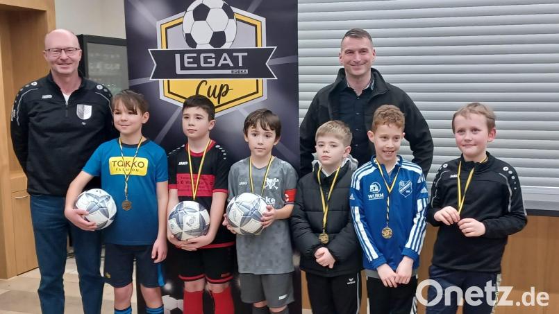 Siegerehrung bei den E2-Junioren im Beisein von Hauptsponsor Stefan Legat (hinten, rechts) und Turnierleiter Joachim Herbrecher von der DJK Neustadt (hinten ,links). Stolz präsentieren die Spielführer der drei Erstplatzierten Ball und Medaille. Bild: Katja Neupert/exb