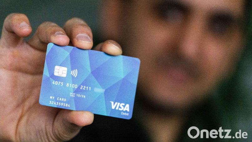 Ein Geflüchteter hält eine Debitcard in der Hand. Bild: Philipp von Ditfurth/dpa/Symbolbild