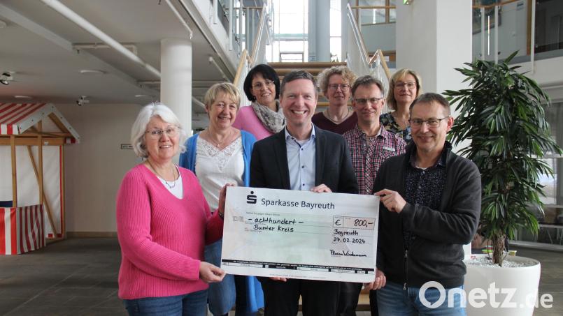 Landrat Florian Wiedemann (vorne Mitte) und Mitarbeitende, die sich an der Bastel- und Spendenaktion beteiligt haben, übergaben den Spendenschecks an Barbara Koch (links) vom Bunten Kreis. Bild: Landratsamt Bayreuth/exb