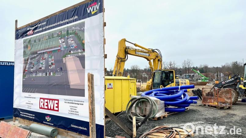 Die Bautafel zeigt schon mal, wie es ab Herbst aussehen könnte an der Tachauer Straße. Die Arbeiten für den neuen Rewe-Markt laufen dort auf Hochtouren. Bild: Gabi Schönberger