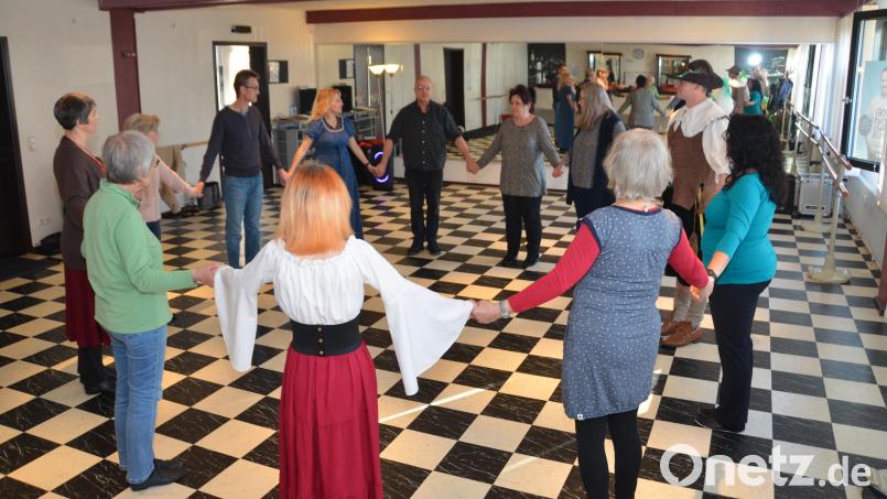 Zusammen mit dem &quot;Lehrmeister&quot; der mittelalterlichen Tänze, Bernd Rzepka aus Amberg, lernen die Teilnehmer des VHS-Workshops erste Schrittfolgen. Bild: exb