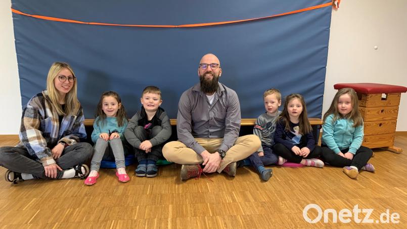 Erste Sitzprobe auf den neuen Sitzkissen, die Elternbeiratsvorsitzender Sebastian Arnold (Vierter von rechts) an Stephanie Miosga (links), die Leiterin des AWO-Kindergartens &quot;Kinderstodl&quot; in Püchersreuth, übergab. Bild: Birgitta Bösl/exb