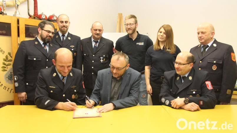 Bürgermeister Markus Bauriedl (sitzend, Mitte) und Kommandant Stefan Lang (sitzend, links) unterzeichnen die Gründungsurkunde für die Kinderfeuerwehr Pfrentsch. Darüber freuen sich neben Vorsitzendem Thomas Müller (sitzend, rechts) Kreisbrandinspektor Martin Weig, Janine Scherer, Johannes Kleber, Stefan Krämer, Anton Zimmermann und Bernd Werner (hinten, von rechts). Bild: pi