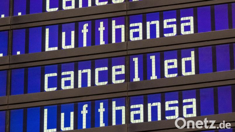 Anzeigentafeln zeigen „cancelled“ und „Lufthansa“ am Flughafen München an. Bild: Peter Kneffel/dpa/Symbolbild