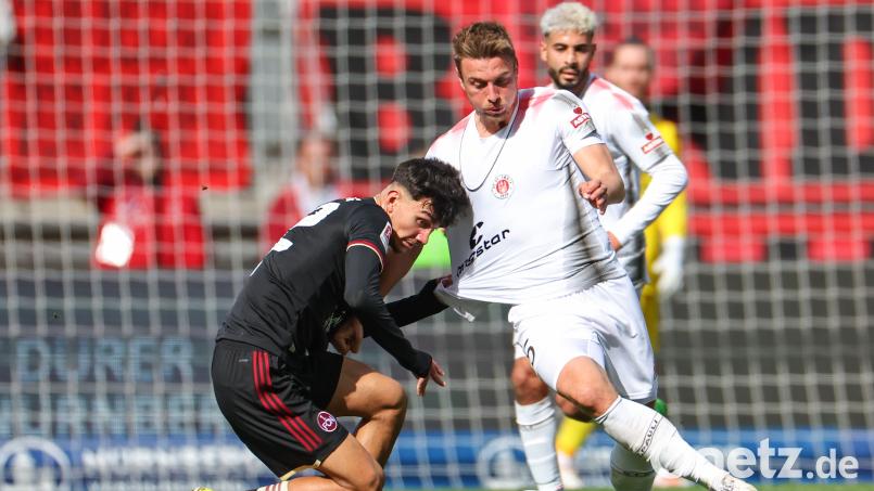 Der 1. FC Nürnberg ging vor dem FC St. Pauli in die Knie: In dieser Szene jagt der Hamburger Hauke Wahl (rechts) Club Stürmer Can Uzun den Ball ab. Bild: Daniel Karmann/dpa