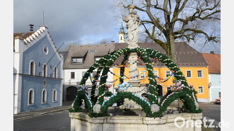 Ketten aus bunten Eiern zieren derzeit den Brunnen am Marktplatz in Pleystein. Bild: bey