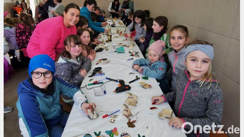 Jugendbeauftragte Laura Roth zeigt den Kindern, wie aus Birkenscheiben kleine Holz-Osterhasen werden. Bild: gz