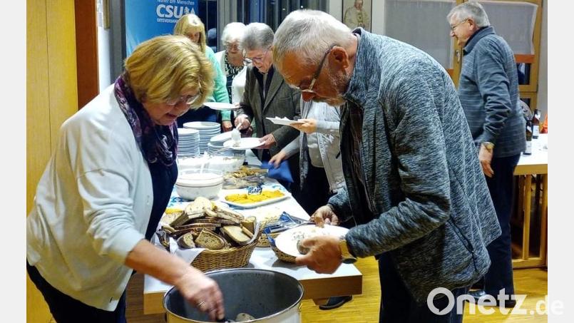 FU-Vorsitzende Renate Müller hilft, die heißen Kartoffeln aus dem Topf zu holen. Favorit beim Fischessen sind natürlich die marinierten Heringe. Bild: wlr