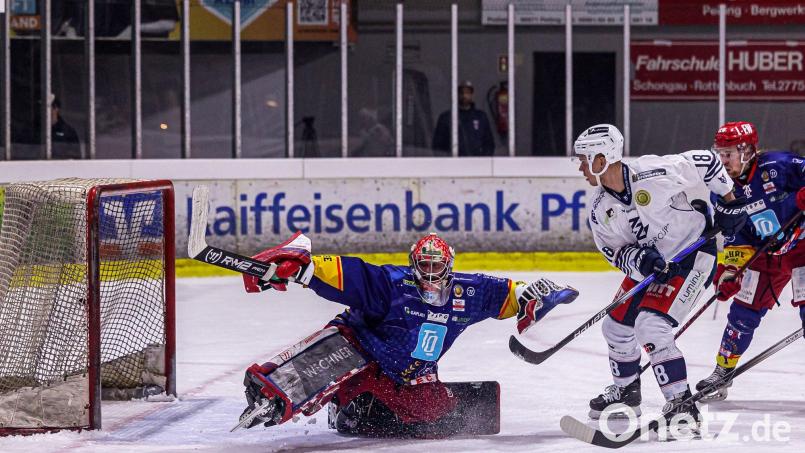 Der Weidener Vincent Schlenker (weißes Trikot) taucht vor dem Peitinger Goalie Andreas Magg auf. Die Blue Devils gewannen am Freitag auch das vierte Viertelfinal-Match gegen den EC Peiting und stehen damit im Play-off-Halbfinale. Bild: Werner Moller
