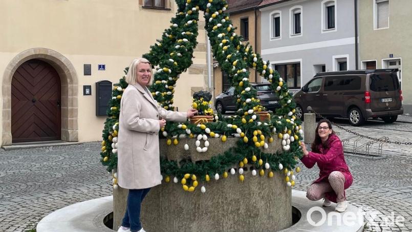 Barbara Hößl-Bauer (rechts) und Claudia Wolf (links) verpassten dem Osterbrunnen den letzten Schliff, so dass sich Besucher des Rathauses oder Spaziergänger sich an dem leuchtenden Anblick erfreuen können. Bild: myd