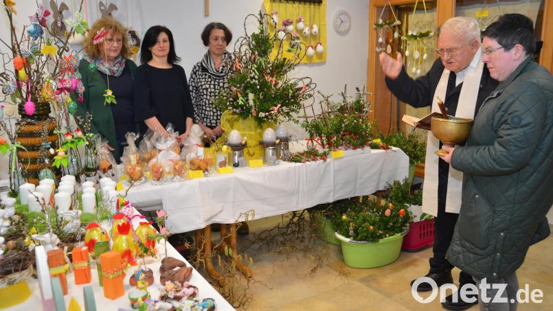 Pfarrer Gerhard Schmidt kommt gleich nach der Eröffnung zur Segnungshandlung im Erdgeschoß des Pfarrheims vorbei. Mitglieder des Frauenbunds haben in kreativer Vorarbeit wieder alles bunt für den Palmsonntagsbasar erstrahlen lassen und richtige Hingucker hergestellt. Bild: dob