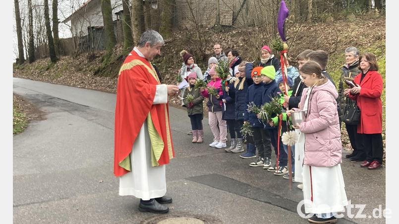 Pfarrer Adam Nieciecki spricht das Segensgebet vor den Kindern für die Palmzweige. Bild: sl