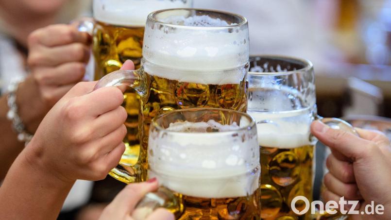 Besucher stoßen auf dem Münchner Oktoberfest mit Bier an. ( Bild: Matthias Balk/dpa/Archivbild