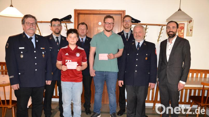 Unter Beifall der anwesenden Feuerwehrleute und des Führungsteams werden per Handschlag die beiden Nachwuchskräfte Ben Bodensteiner (links) und Christoph Kraus in die Wehr aufgenommen. Dazu gratulieren KBM Thomas Kleber (links) und Bürgermeister Armin Bulenda (rechts). Bild: gi